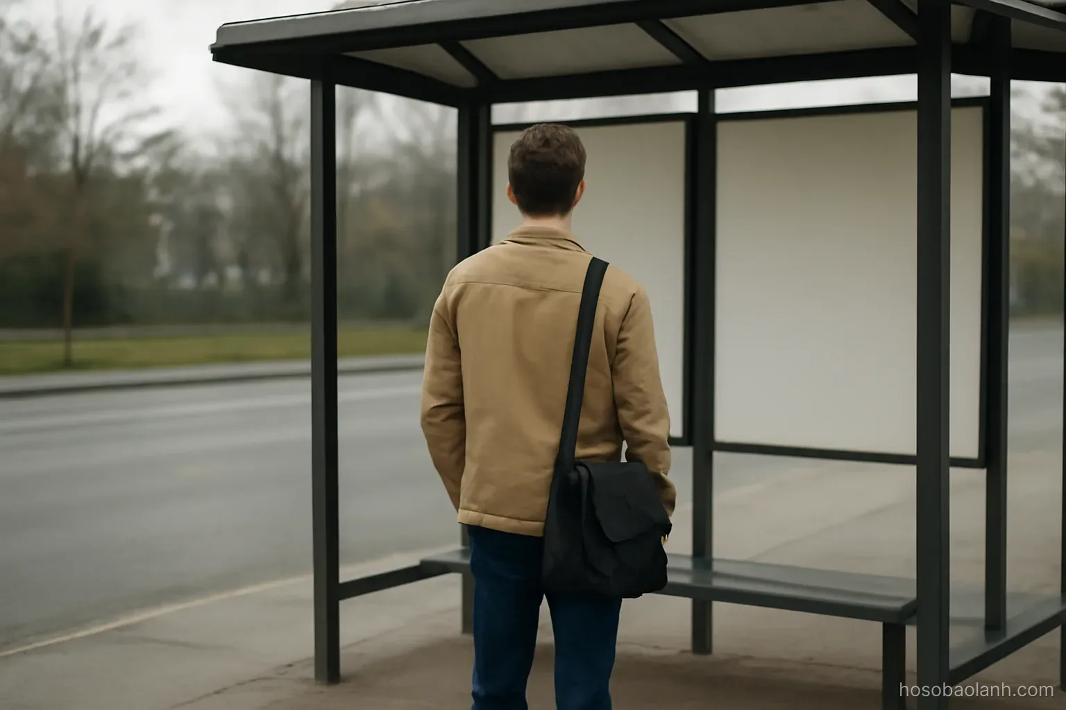 a young adult standing at a bus stop with a bag, seen from a distance, no signage, overcast light